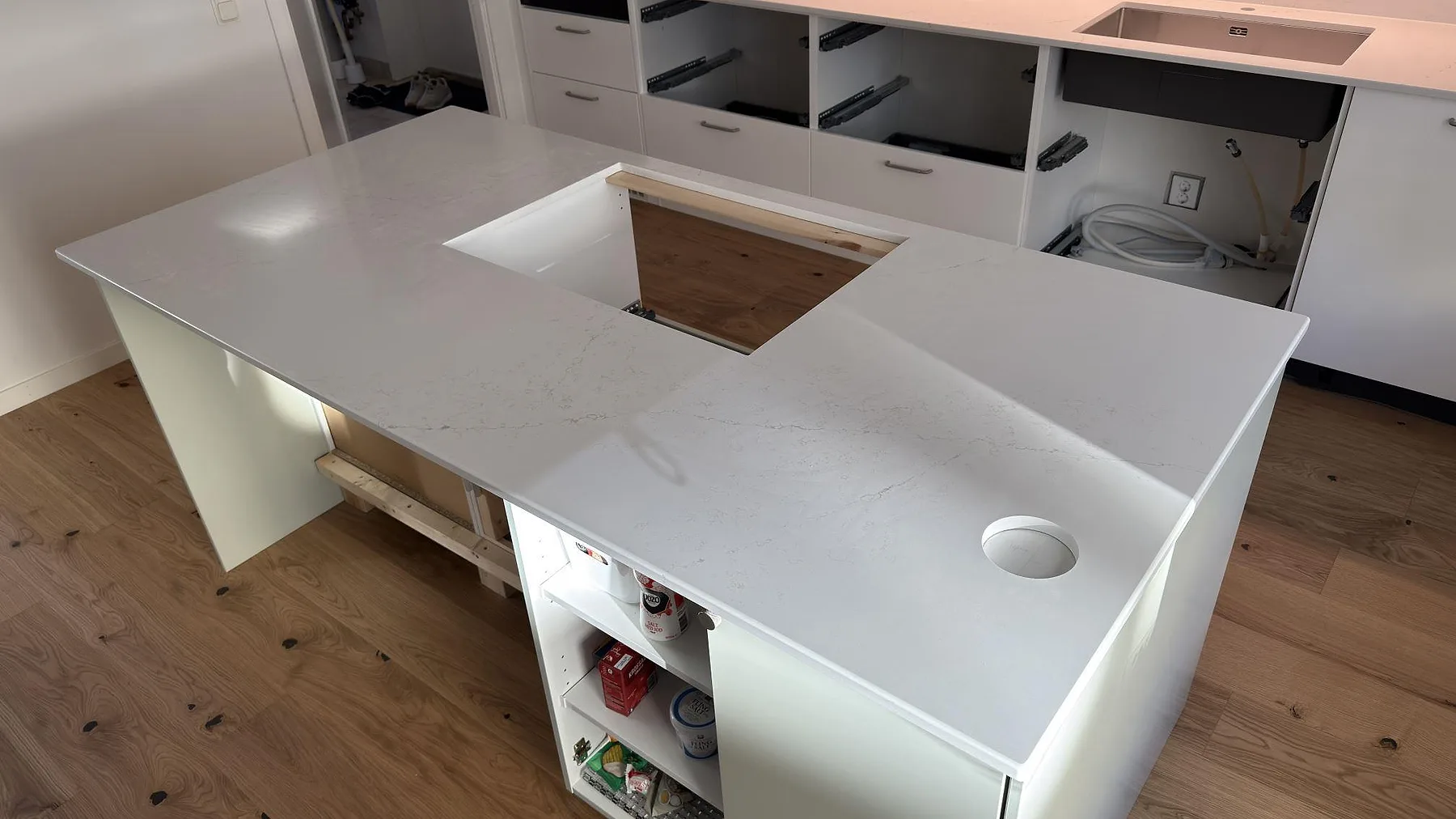 Närbild av köksö i polerad Silestone Siberian frost med hällurtagning, runt genomföringshål och ljus grå ådring i Norrköping.