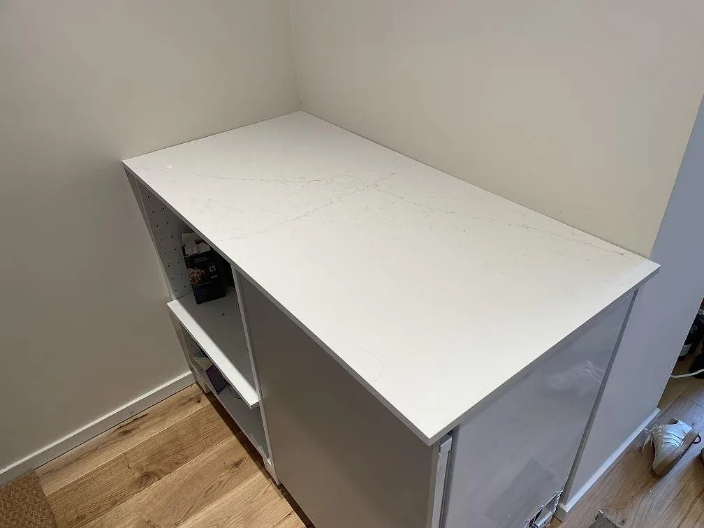 Polerad bänkskiva i Silestone Siberian Frost på en mindre kökssektion under montering i Stockholm.