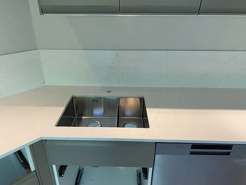 Diskbänksyta i polerad Silestone Siberian frost med dubbel diskho och 12 mm stänkskydd i köket i Veberöd.
