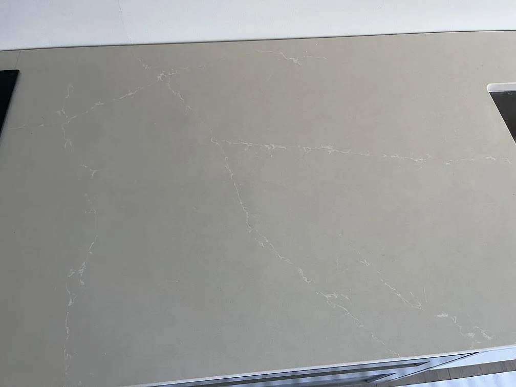 Greige Silestone Silken Pearl köksbänkskiva med diskret ådring och plats för induktionshäll i ett kök i Staffanstorp.