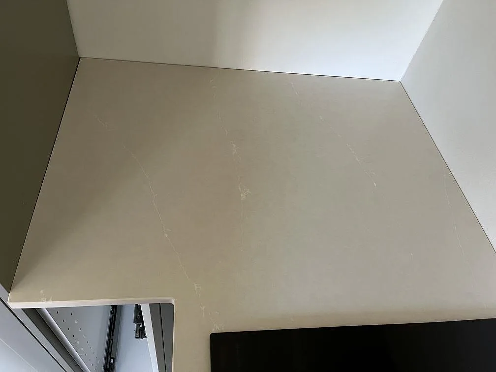 Köksbänkskiva i Silestone Silken Pearl mot vägg med mjukt ljusgreige yta och fin ådring i ett kök i Staffanstorp.