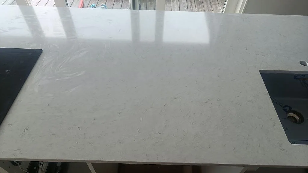 Polerad Silestone Snowy Ibiza som köksbänkskiva med häll, diskho och ljus ådring framför fönster i Åskloster.