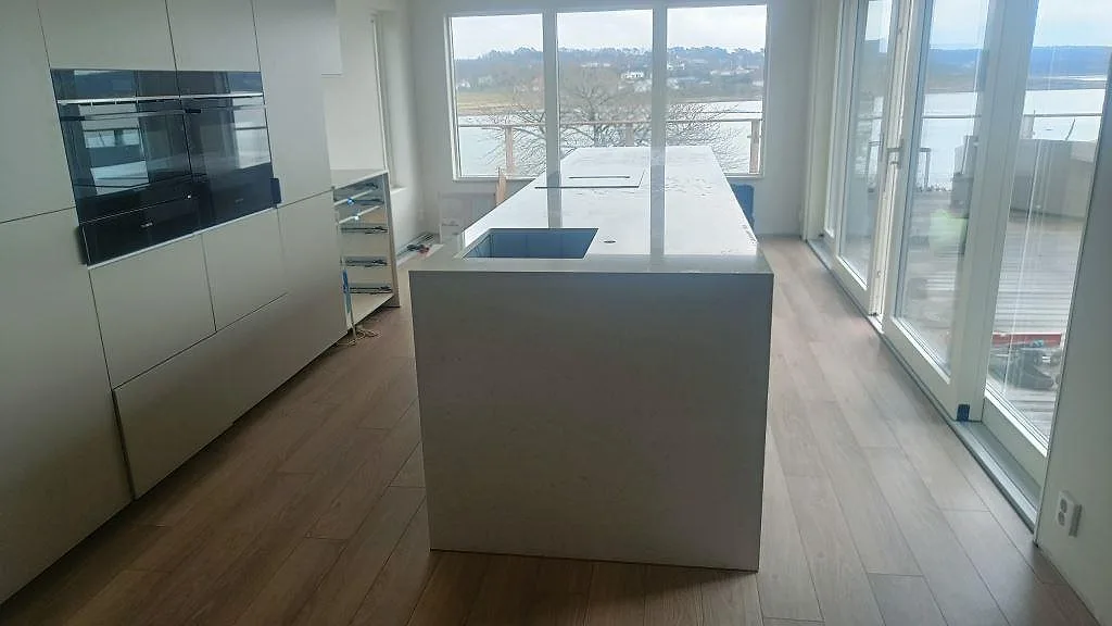 Köksö och köksbänkskiva i polerad Silestone Snowy Ibiza med underlimmad diskho och häll i ett kök i Åskloster.