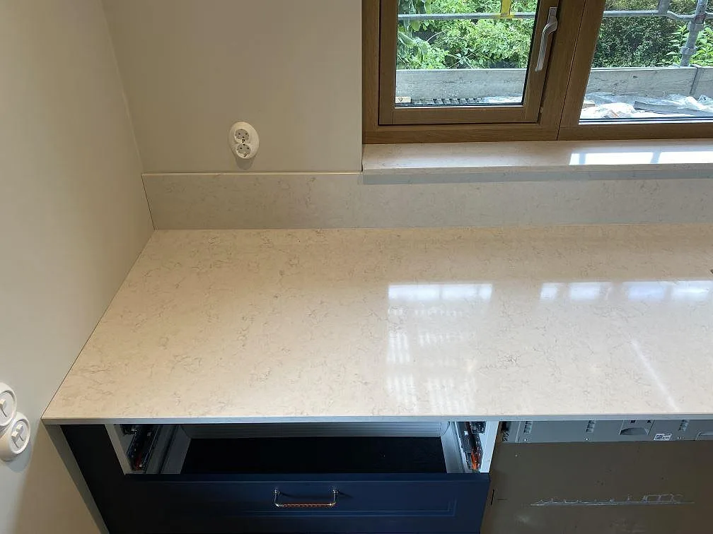 Rak bänksektion i polerad Silestone Snowy Ibiza med fönsternisch och stänkkant i samma ljusa sten i Arlöv.