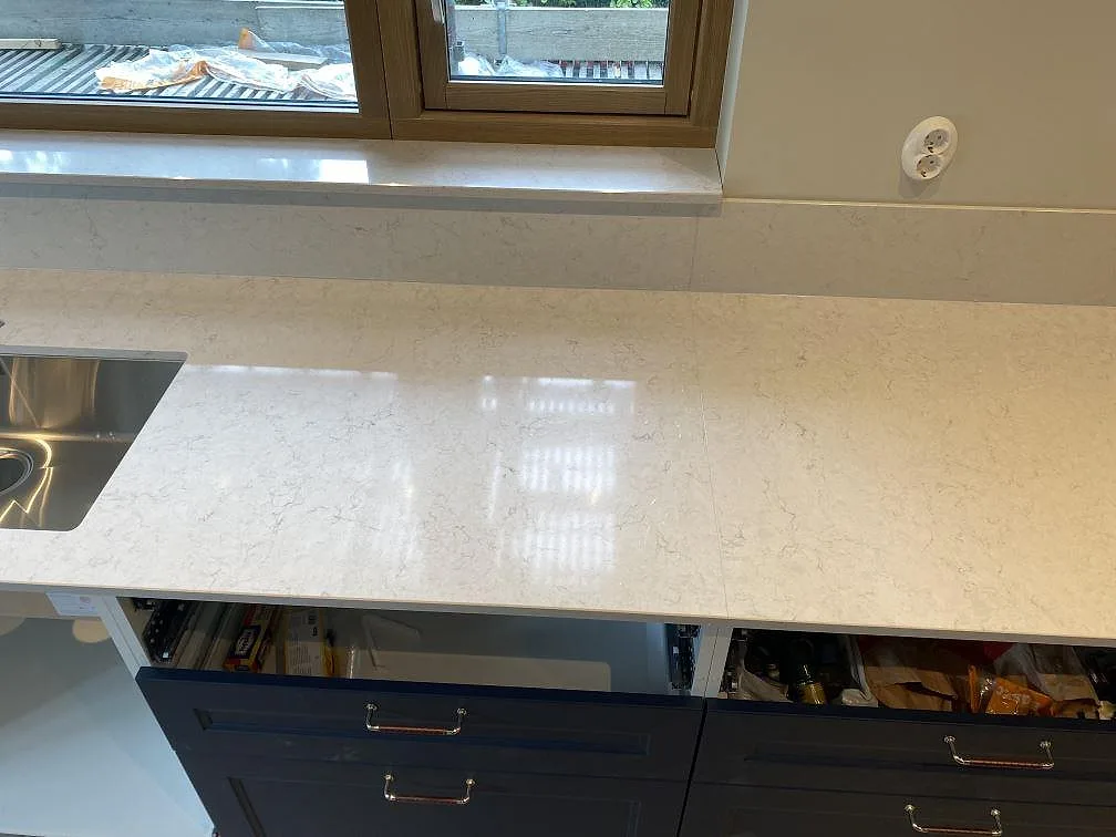 Ytdetalj av polerad Silestone Snowy Ibiza med diskho vid sidan, ljus kvartskomposit på köksbänk i Arlöv.