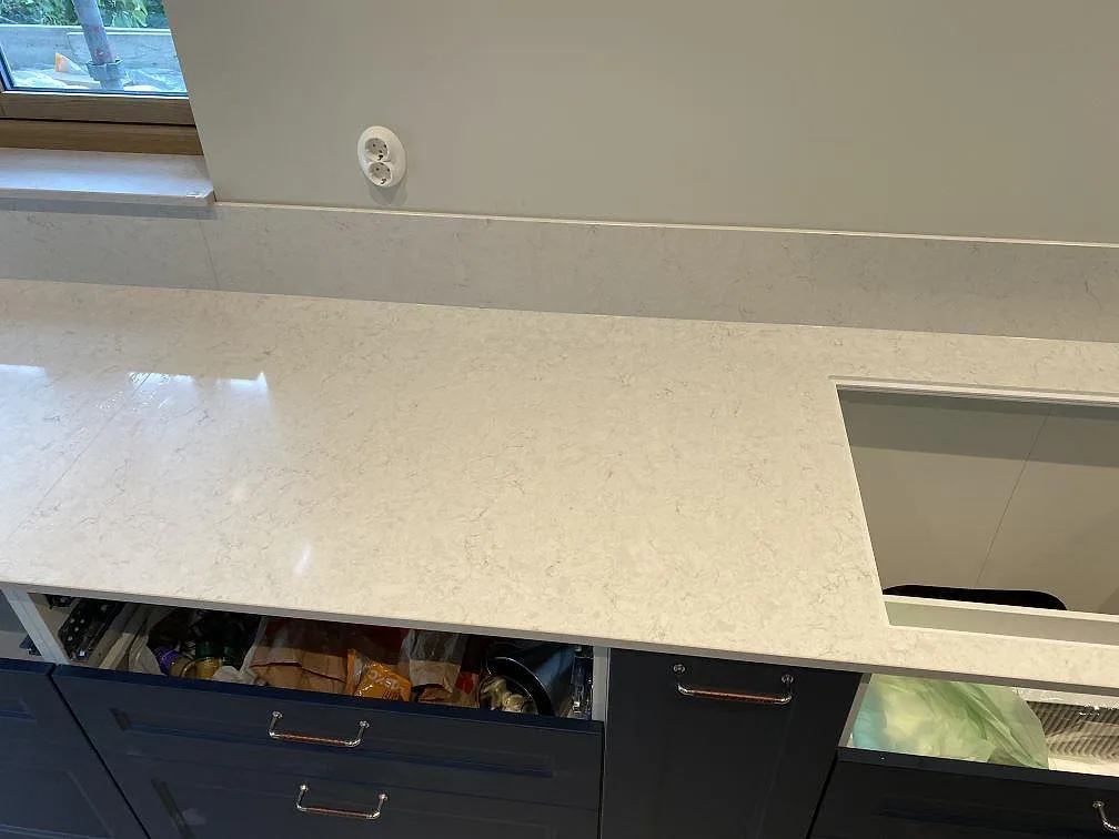 Detalj av hällurtag i polerad Silestone Snowy Ibiza med ljus ådring och uppvikt stänkkant i ett kök i Arlöv.