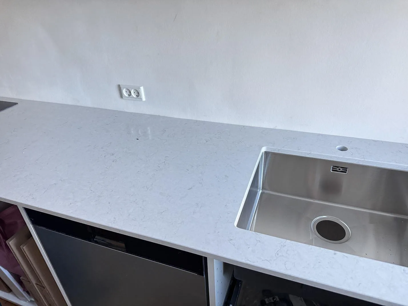 Köksbänkskiva i polerad Silestone Snowy Ibiza med rostfri diskho, blandarhål och öppna köksstommar i Bagsværd.