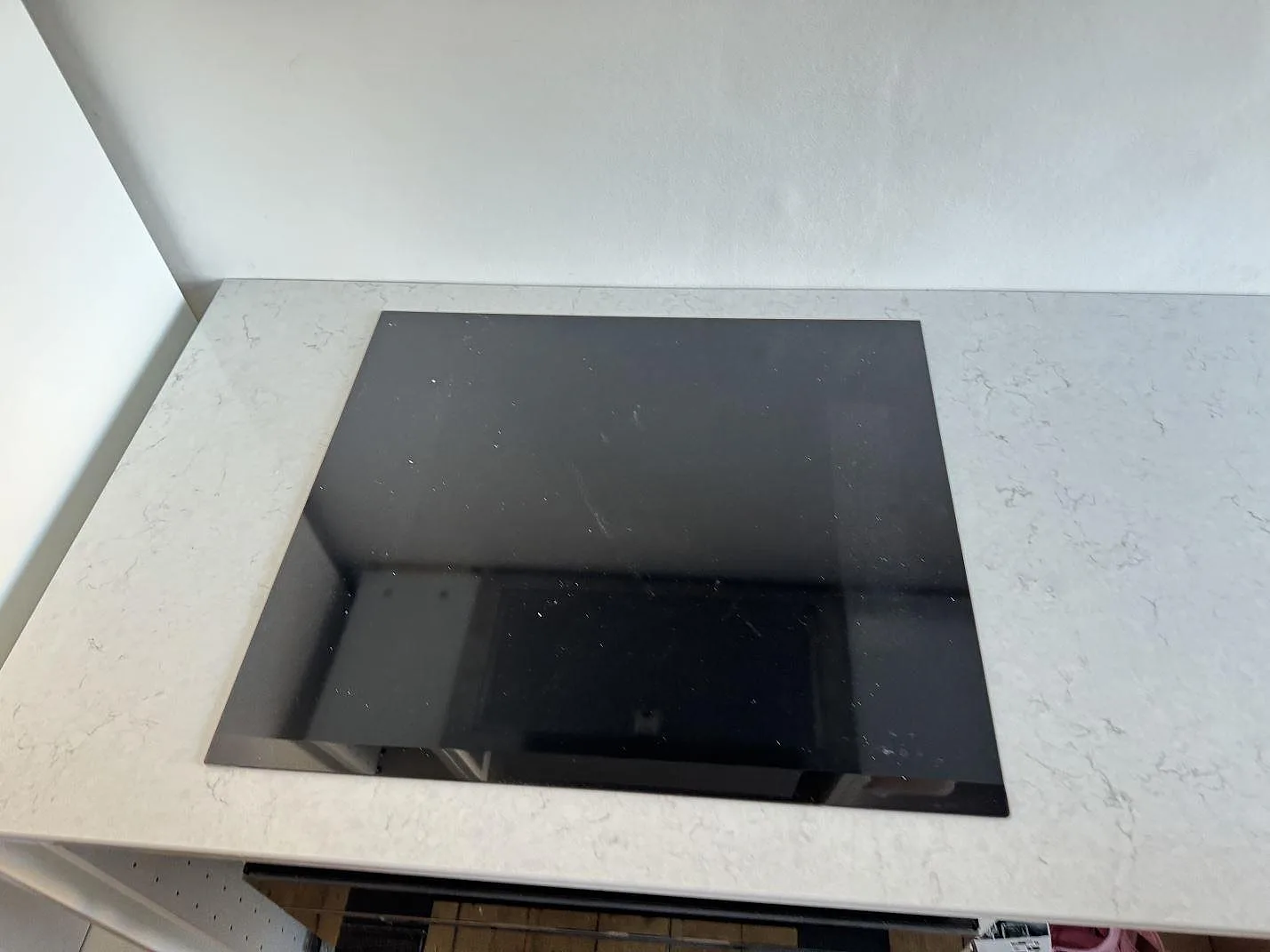 Svart häll infälld i polerad Silestone Snowy Ibiza köksbänkskiva med ljus kvartskomposit runt arbetszonen i Bagsværd.