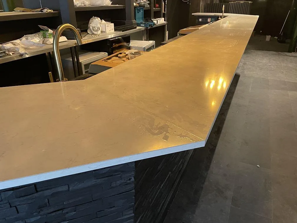 Blank bardiskyta i Silestone Snowy Ibiza komposit med ljusa mönster och lång serveringslinje i Borås.