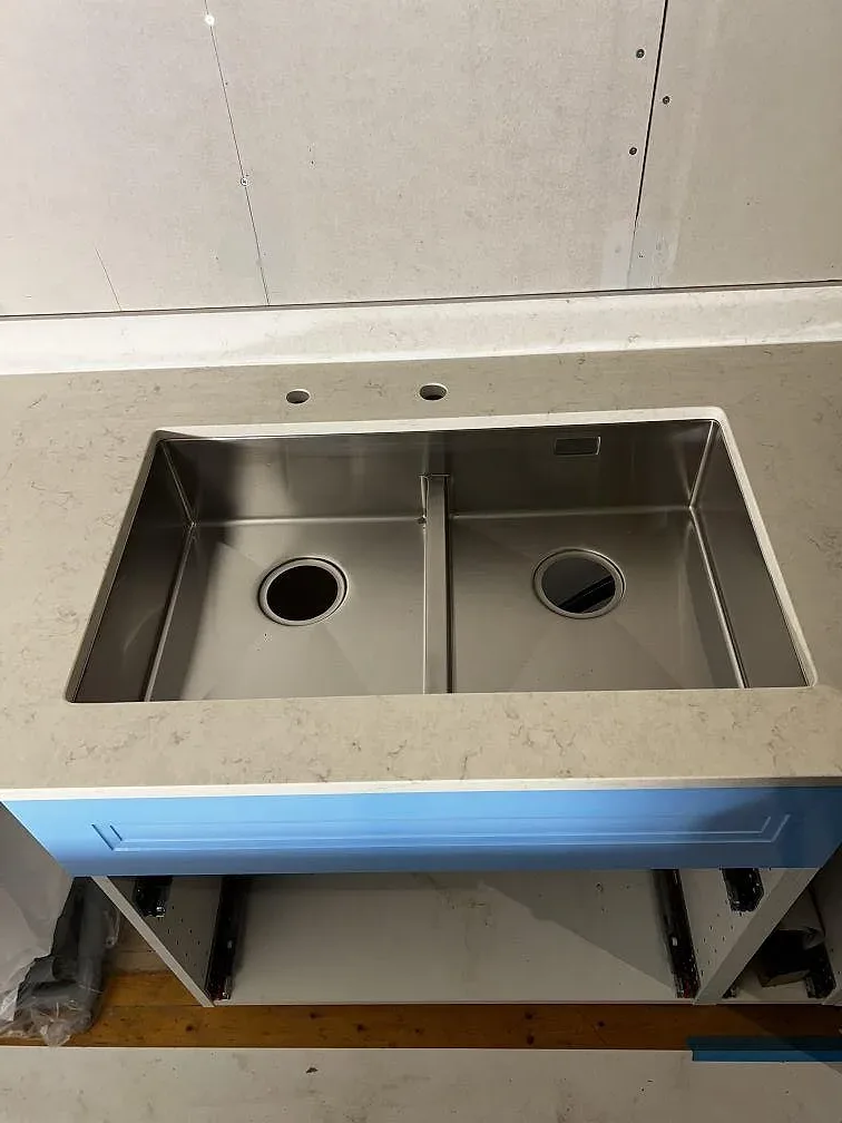 Dubbel underlimmad rostfri diskho monterad under en polerad Silestone Snowy Ibiza bänkskiva i Borrby.