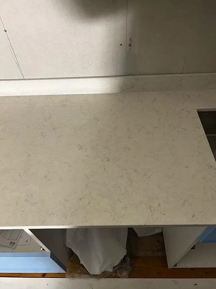 Detaljbild av ljus polerad Silestone Snowy Ibiza bänkskiva med mjuk ådring i ett kök i Borrby.