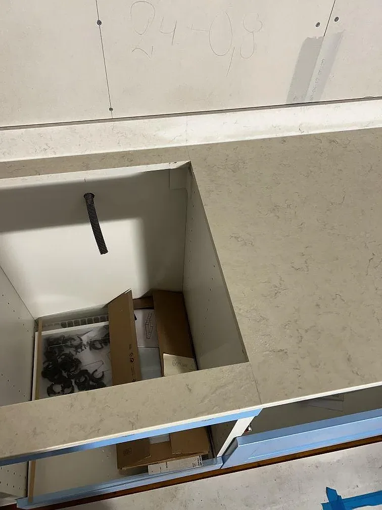 Polerad Silestone Snowy Ibiza runt ett urtag i köksbänkskivan med öppna stommar under montering i Borrby.