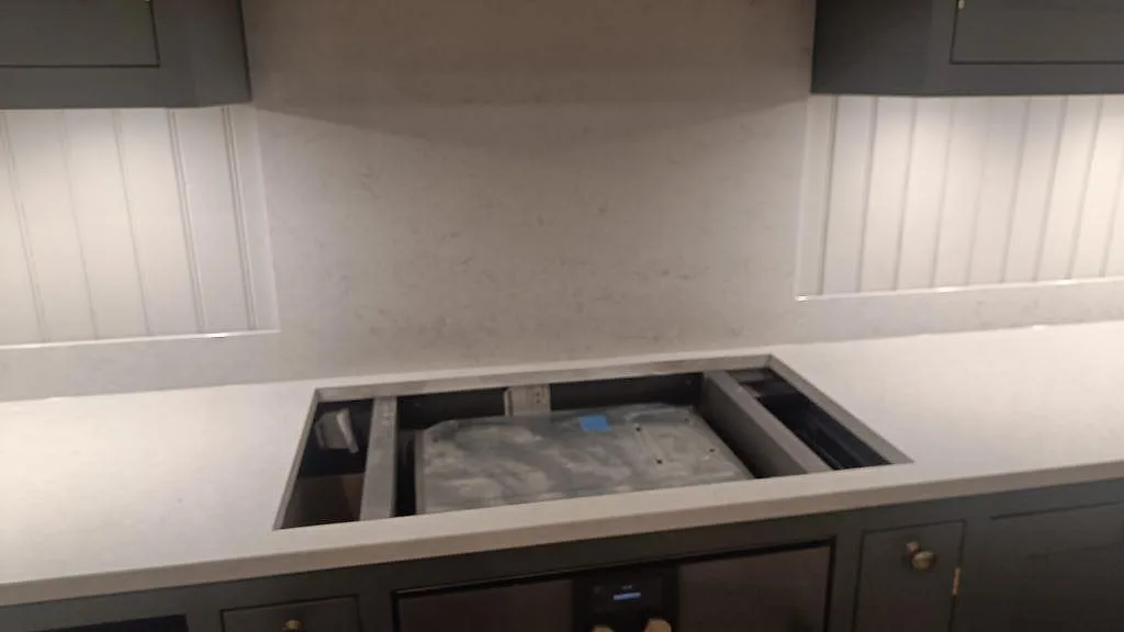 Köksbänkskiva i polerad Silestone Snowy Ibiza med monteringsöppning och stänkkant mot vägg i Braås.