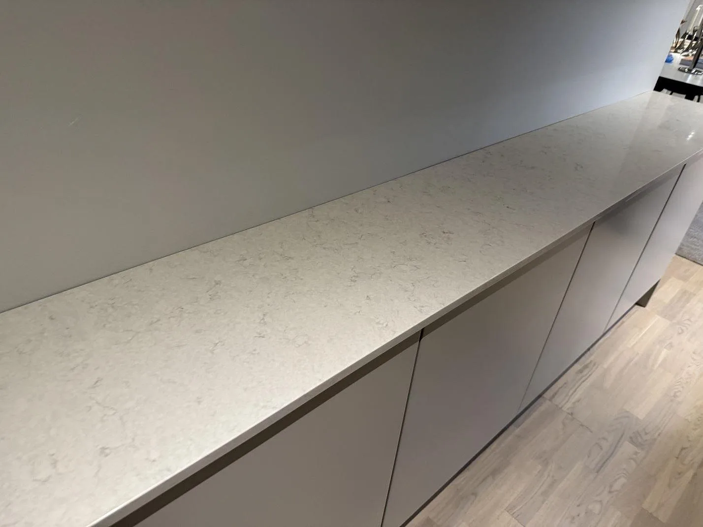 Närbild av polerad Silestone Snowy Ibiza med mjuk grå ådring på en lång bänkskiva i Bunkeflostrand.