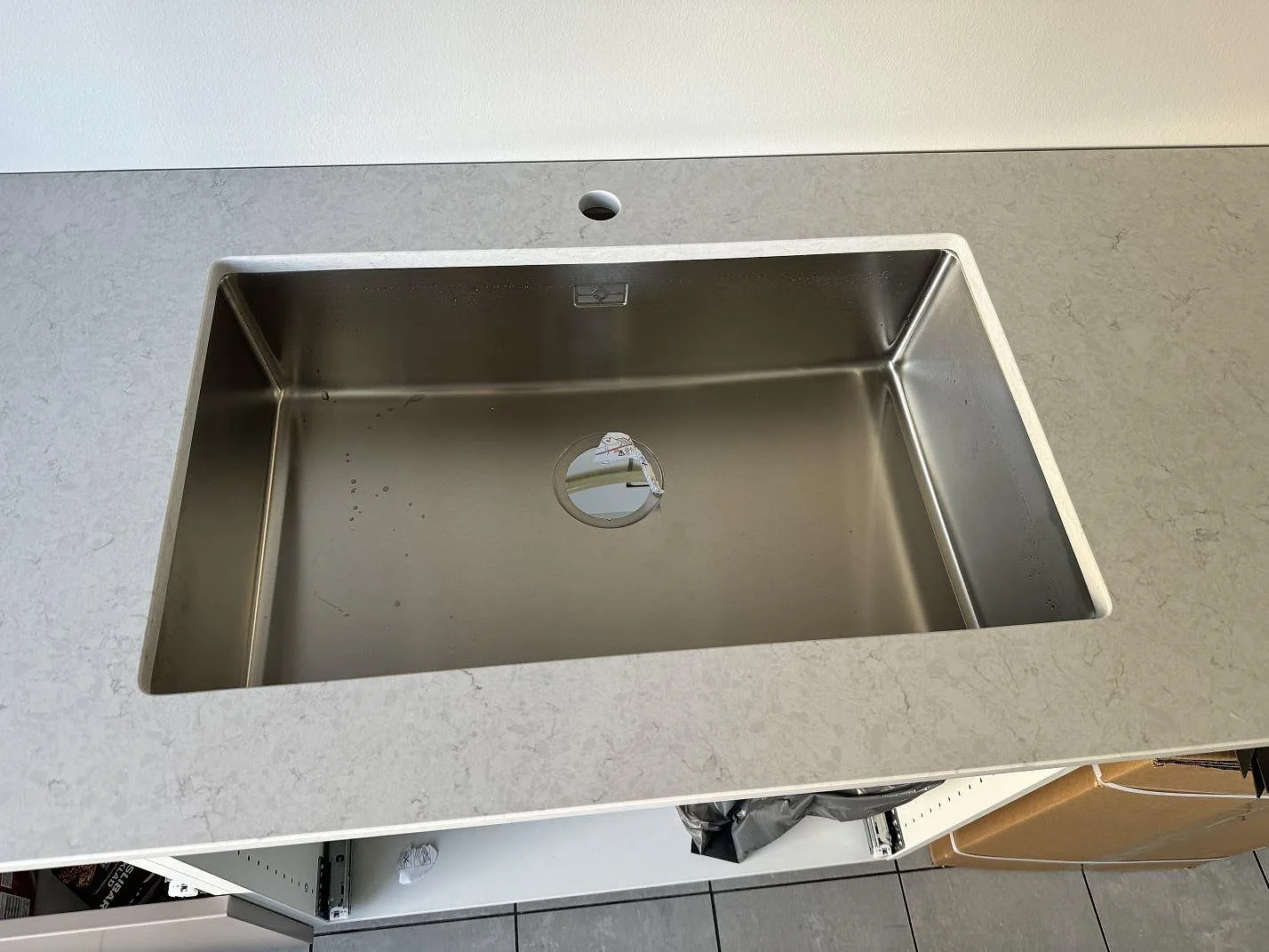 Detalj av underlimmad rostfri diskho i polerad Silestone Snowy Ibiza köksbänkskiva med blandarhål i Bunkeflostrand.