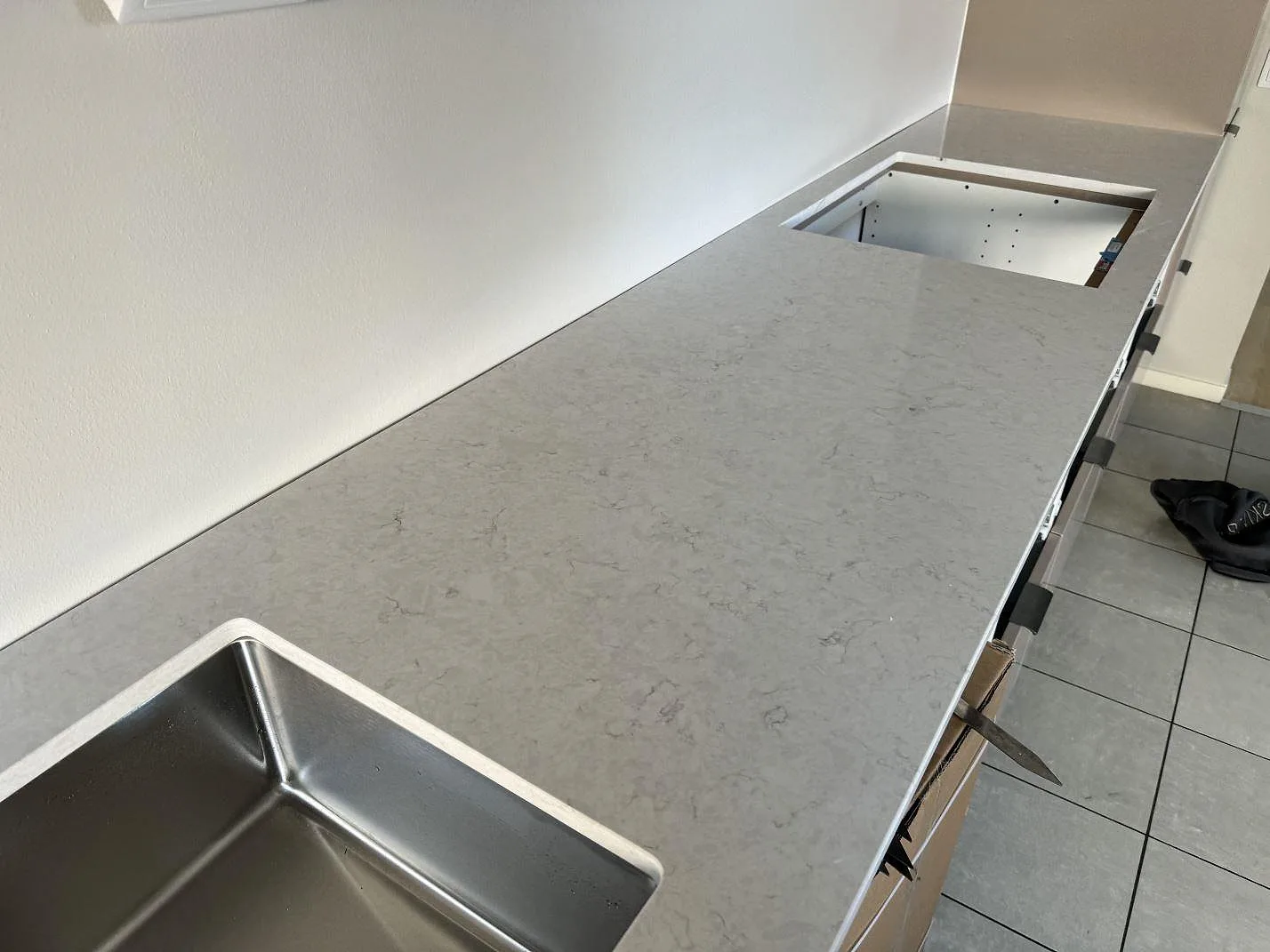 Köksbänkskiva i polerad Silestone Snowy Ibiza med rostfri underlimmad diskho, hällurtag och låg stänkkant i Bunkeflostrand.