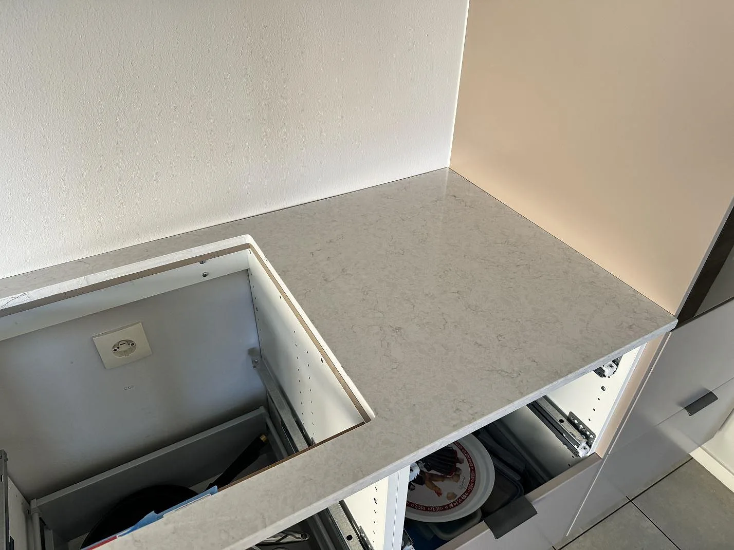 Hörnvy av polerad Silestone Snowy Ibiza köksbänkskiva med hällurtag och ljus stenådring i Bunkeflostrand.