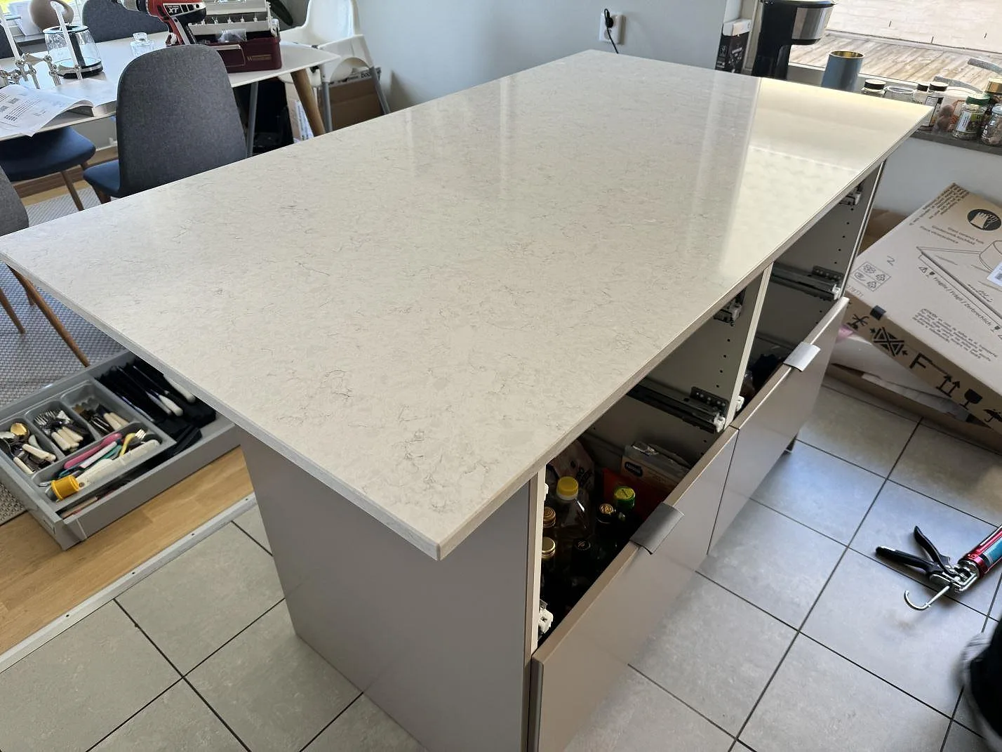 Polerad köksö eller bordsskiva i Silestone Snowy Ibiza komposit med ljus marmorering i ett öppet kök och matrum i Bunkeflostrand.