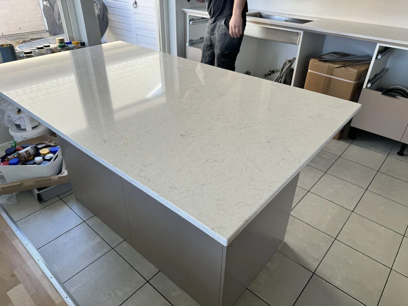 Polerad Silestone Snowy Ibiza som köksö framför en monterad köksbänkskiva med sink och hällurtag i Bunkeflostrand.