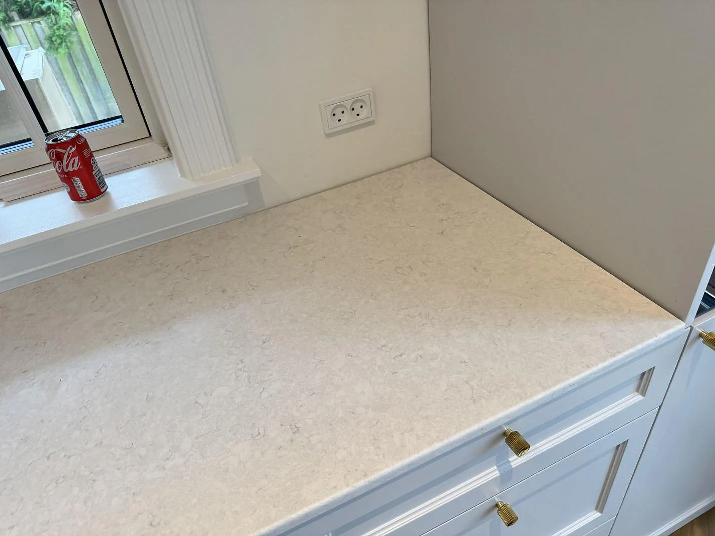 Rak köksbänkskiva i Silestone Snowy Ibiza vid fönster, matt ljus kvartskomposit med grå teckning i Charlottenlund.