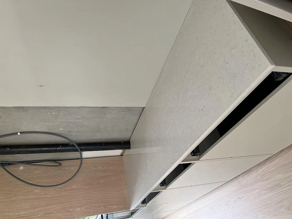 Sned vy av Silestone Snowy Ibiza som polerad kompositbänkskiva på vita köksskåp under montering i Dalby.