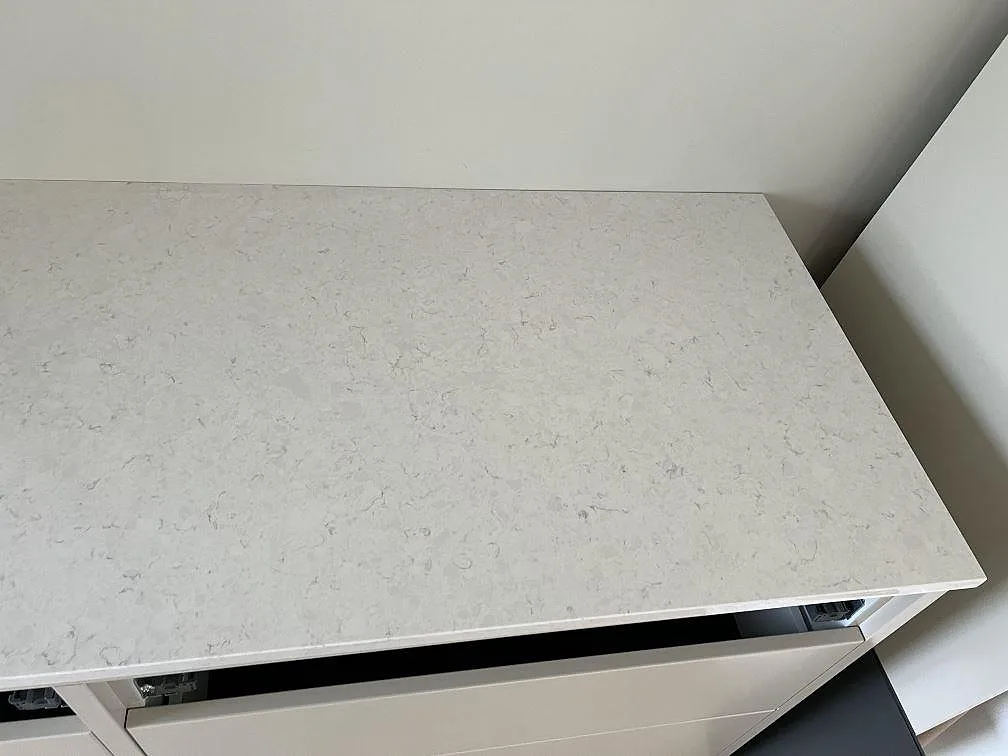 Närbild av polerad Silestone Snowy Ibiza som 20 mm köksbänkskiva på vita köksstommar i Dalby.