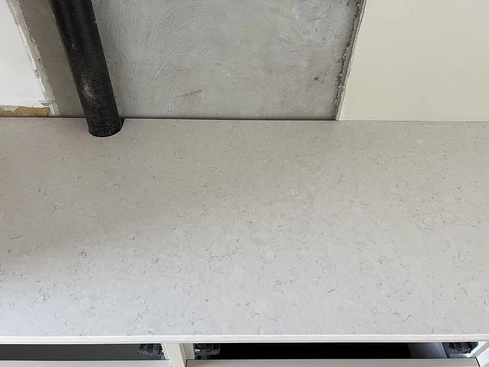 Närbild av ljus köksbänkskiva i Silestone Snowy Ibiza med polerad yta och stänkskydd vid installationsvägg i Dalby.