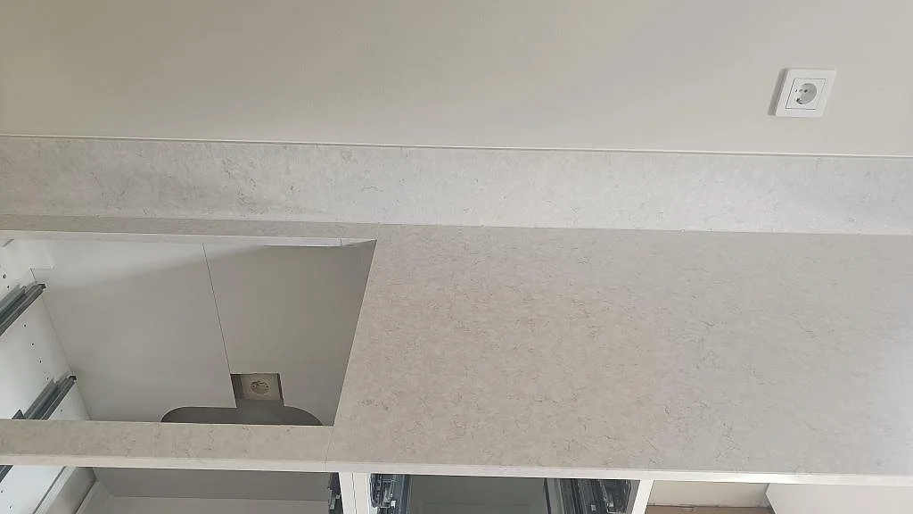 Polerad Silestone Snowy Ibiza som köksbänkskiva med hälluttag, diskho och matchande stänkkant i Falkenberg.