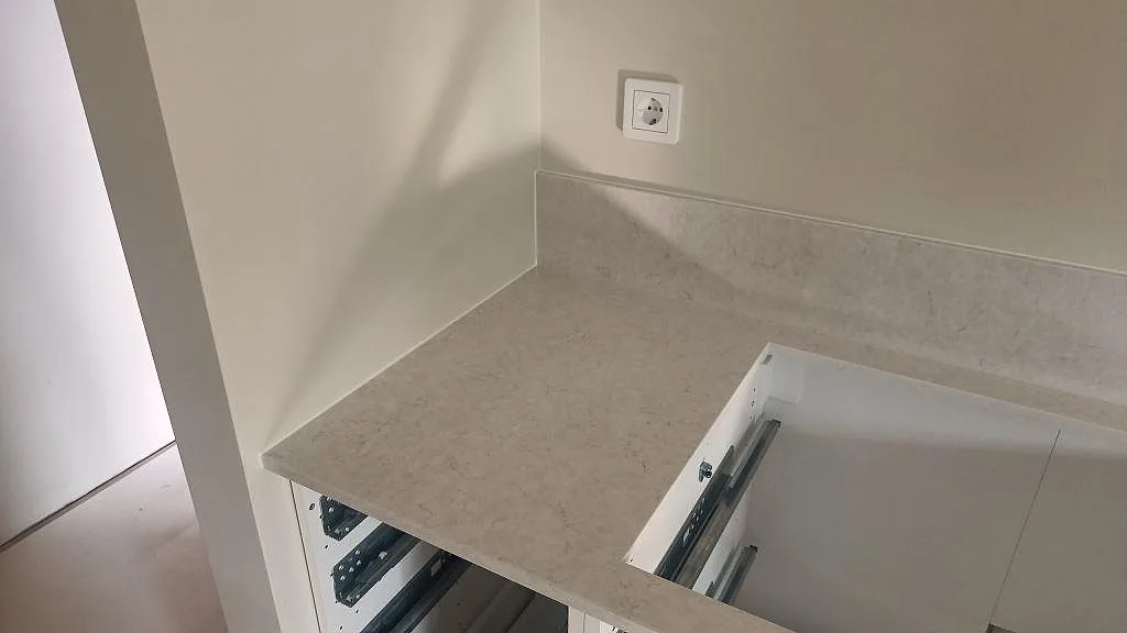 Vinklad vy av polerad Silestone Snowy Ibiza på köksbänkskiva med uppvikt kant i Falkenberg.