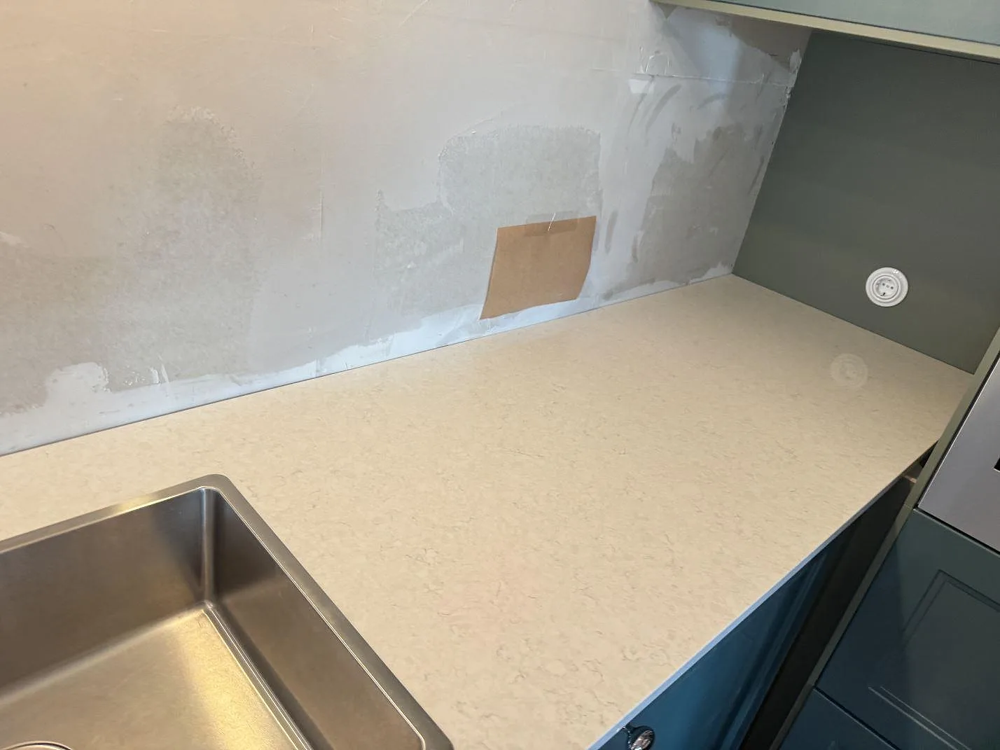 Detalj av polerad Silestone Snowy Ibiza vid diskho och vägg, monterad som köksbänkskiva i Falkenberg.