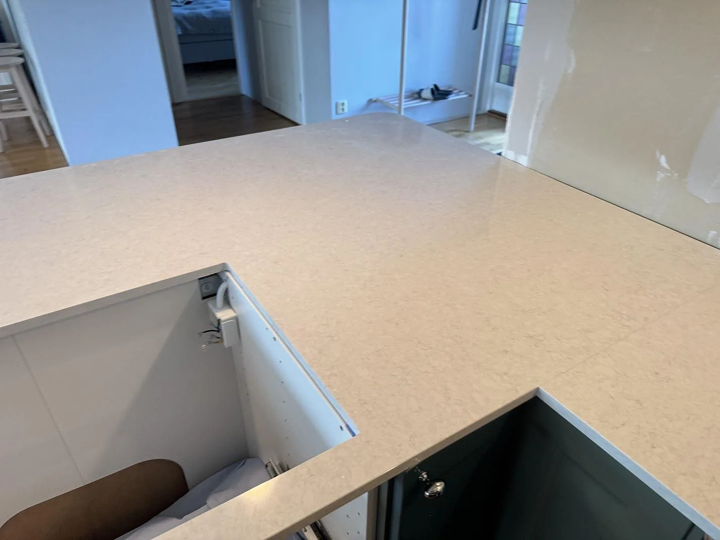 Närbild av köksbänkskiva i polerad Silestone Snowy Ibiza med utsågade öppningar och ljus ådring i Falkenberg.