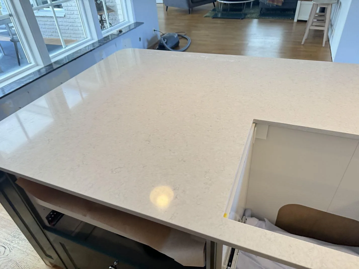 Köksbänkskiva i polerad Silestone Snowy Ibiza med speglingar från fönster och öppning i stommen i Falkenberg.