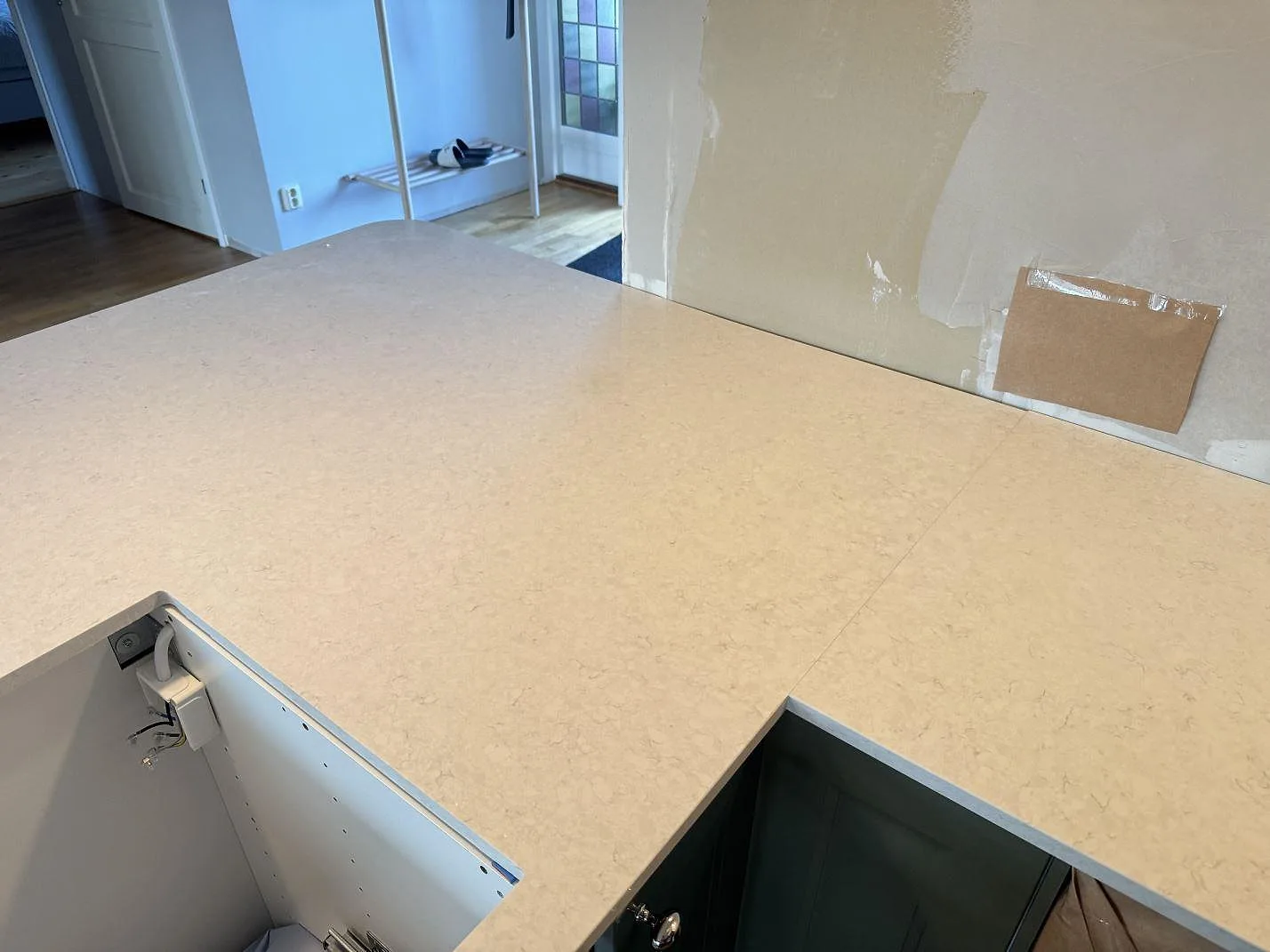 Polerad Silestone Snowy Ibiza som köksbänkskiva med ljus ådring och öppna stommar under montering i Falkenberg.