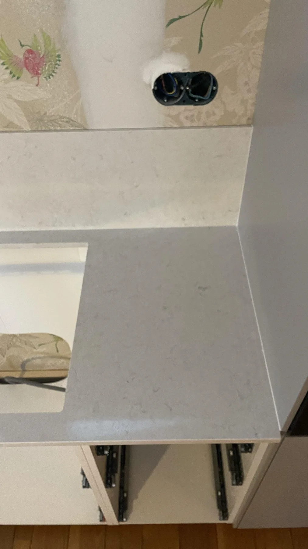 Detalj av polerad Silestone Snowy Ibiza i kvartskomposit vid hällöppningen och stänkskyddet i köket i Fjällbacka.