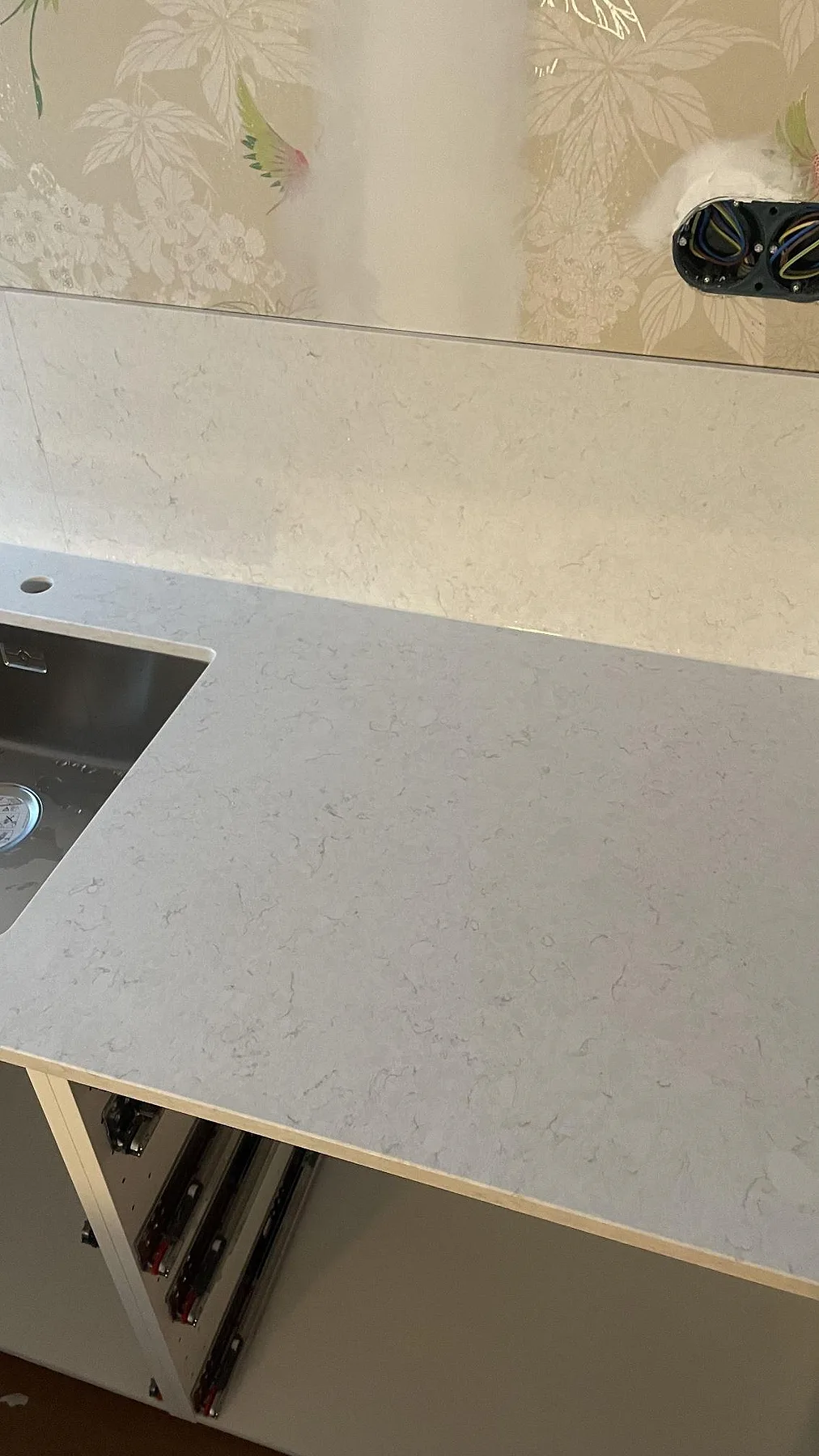Närbild på polerad Silestone Snowy Ibiza i kvartskomposit med diskho, blandarhål och låg stänkkant i köket i Fjällbacka.