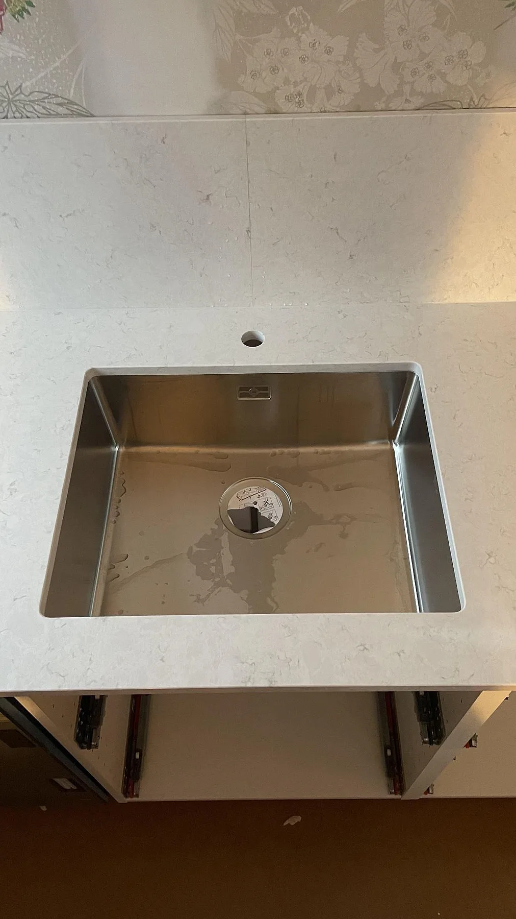 Underlimmad rostfri diskho i en polerad Silestone Snowy Ibiza bänkskiva med matchande stänkskydd i Fjällbacka.