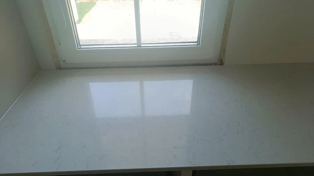 Blank fönsterbänk och köksbänkskiva i polerad vit Silestone Snowy Ibiza i ett kök i Gislaved.