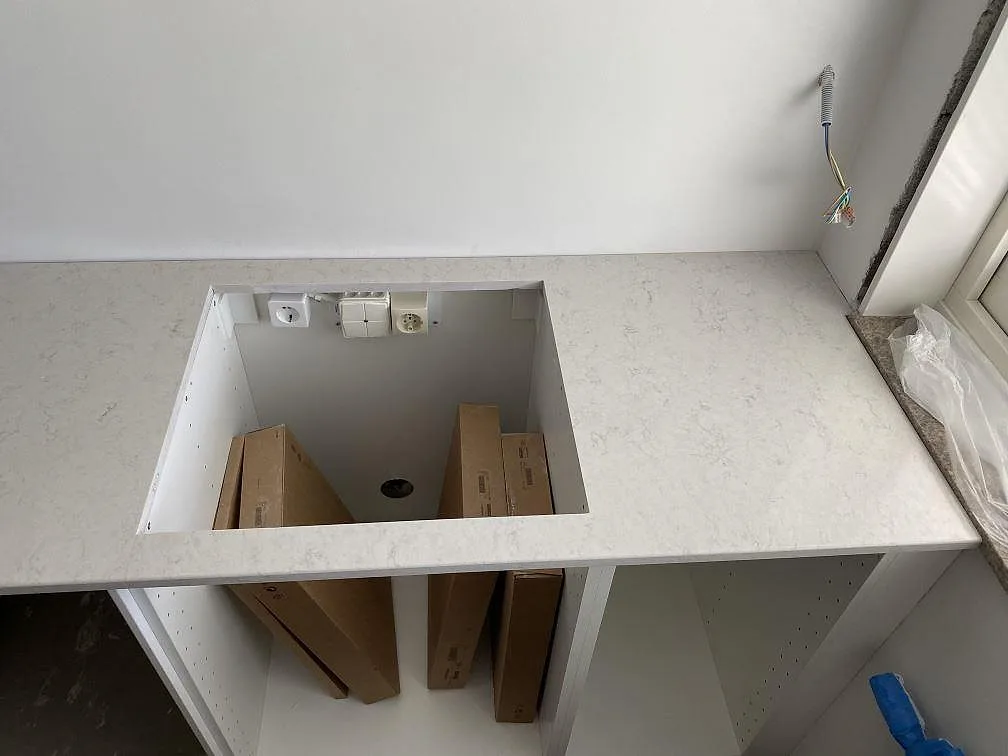 Urtagning för häll i polerad Silestone Snowy Ibiza köksbänkskiva under montering i ett kök i Göteborg.