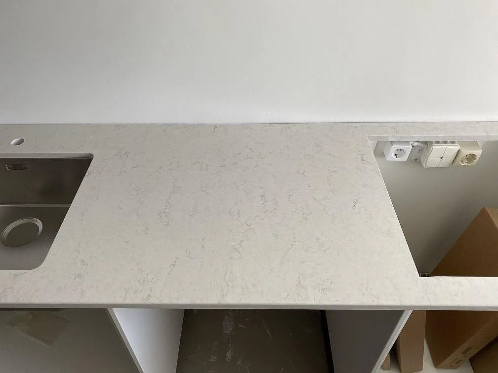 Vit Silestone Snowy Ibiza köksbänkskiva med urtagning för häll och underlimmad diskho, polerad finish, i ett kök i Göteborg.