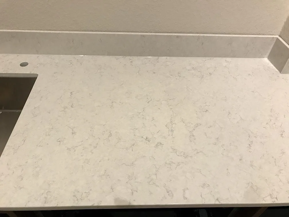 Bänkrad i polerad Silestone Snowy Ibiza med underlimmad rostfri diskho och uppvikt stänkkant i ett kök i Göteborg.
