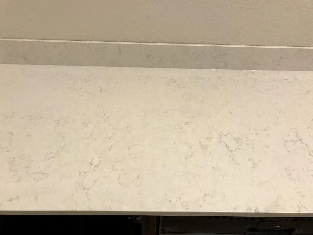 Bänkrad i polerad Silestone Snowy Ibiza med uppvikt stänkkant och mjuk grå ådring i ett kök i Göteborg.