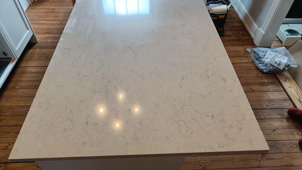 Polerad köksö i Silestone Snowy Ibiza med blank yta och grå ådring i ett kök i Göteborg.