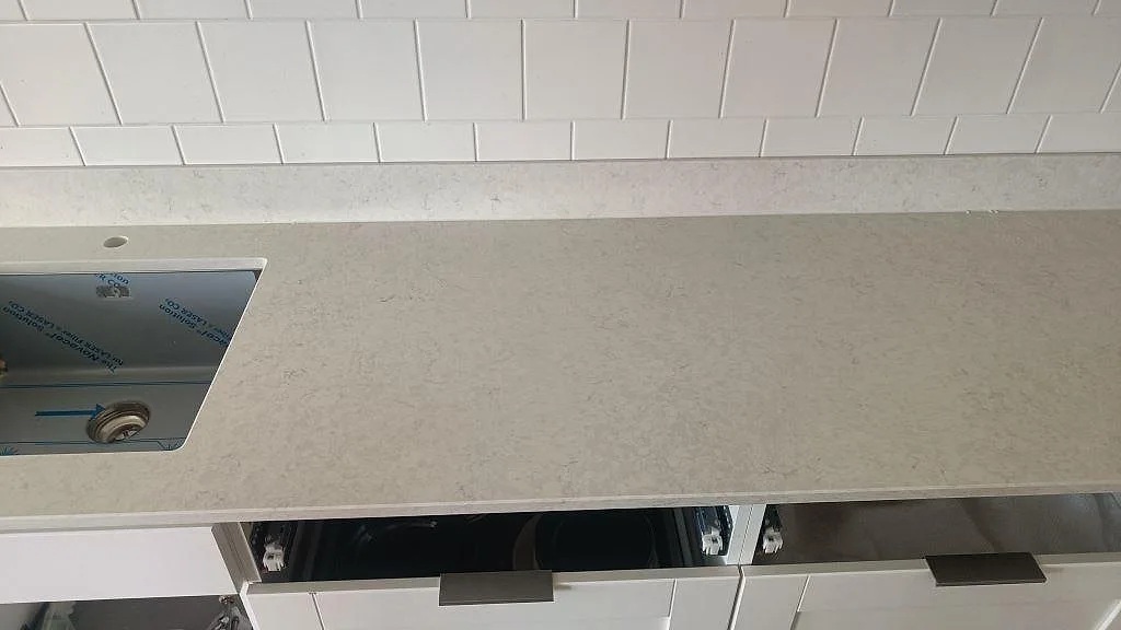 Köksbänkskiva i polerad Silestone Snowy Ibiza komposit med lång arbetsyta, vit köksinredning och underlimmad rostfri diskho i Göteborg.
