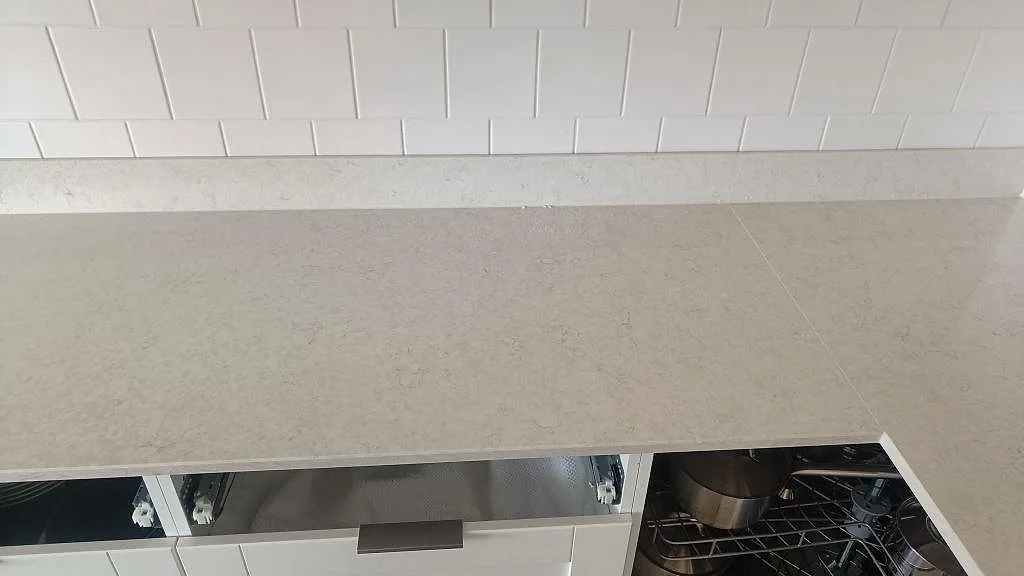 Närbild av polerad Silestone Snowy Ibiza kompositbänkskiva med ljus ådring och låg stänkkant i Göteborg.