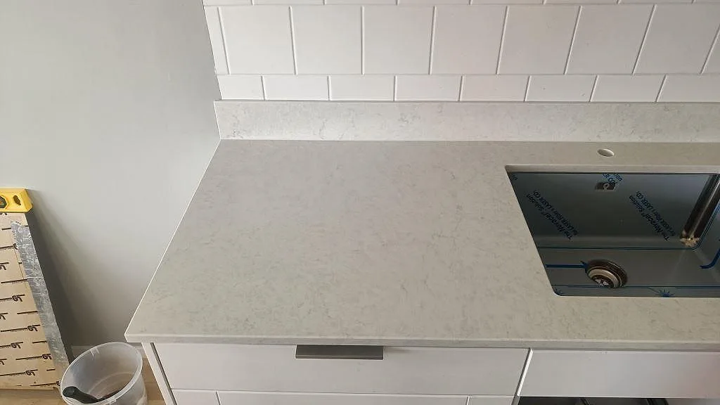 Diskbänk i polerad Silestone Snowy Ibiza med rostfri diskho, blandarhål och matchande stänkkant i Göteborg.