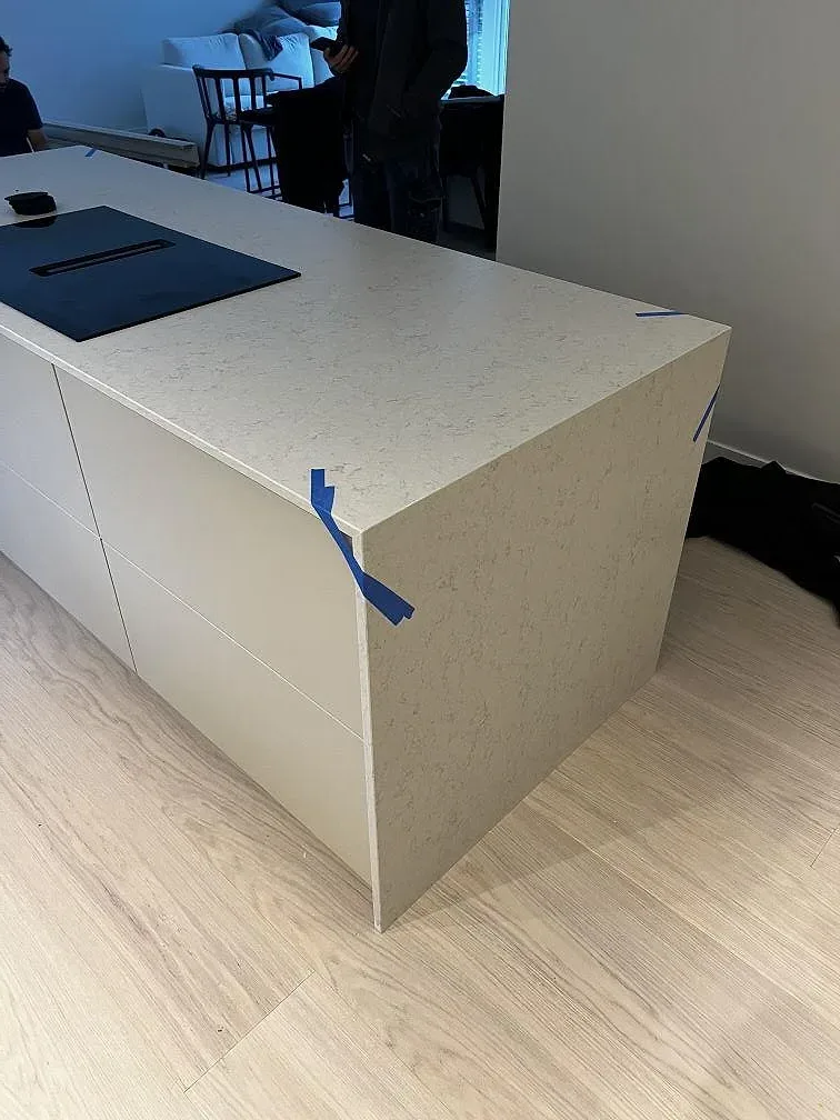 Köksö med bänkskiva i Silestone Snowy Ibiza komposit, Mocka, vit skåpsinredning och ljusa trägolv i Göteborg.