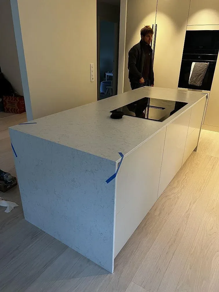 Köksbänkskiva i vit Silestone Snowy Ibiza komposit, Mocka, på köksö med mörk häll i Göteborg.