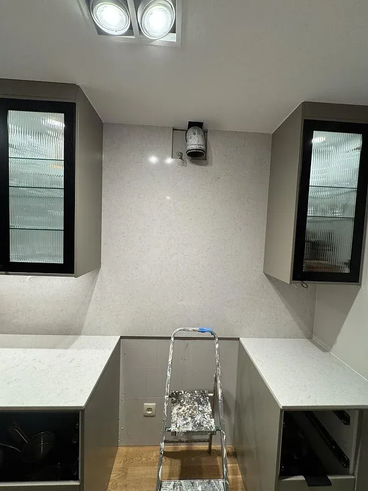 Översikt av kök under montering med polerade bänkskivor och väggbeklädnad i Silestone Snowy Ibiza i Göteborg.