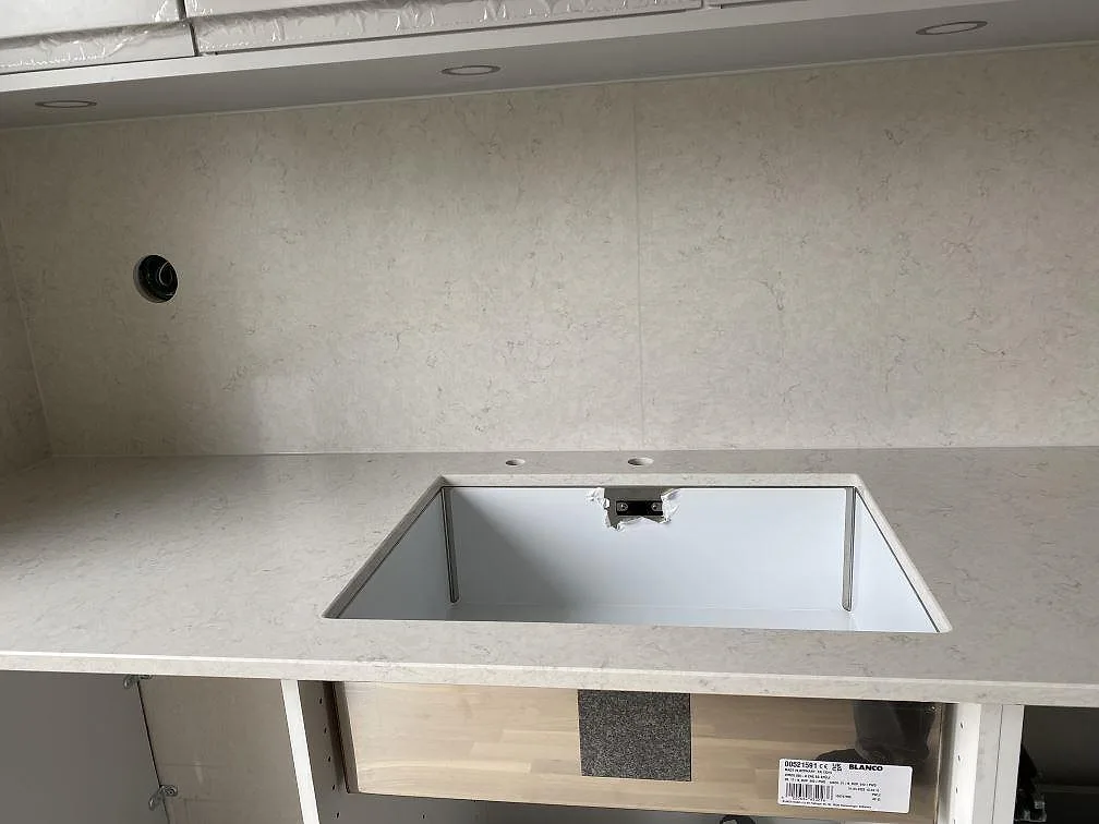 Köksö i polerad vit Silestone Snowy Ibiza med spegelblank yta framför fönsterpartiet i ett kök i Halmstad.