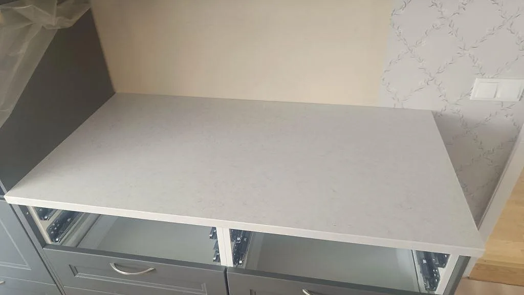 Topvy över matt Silestone Snowy Ibiza som bänkskiva på grå underskåp i Harestad.
